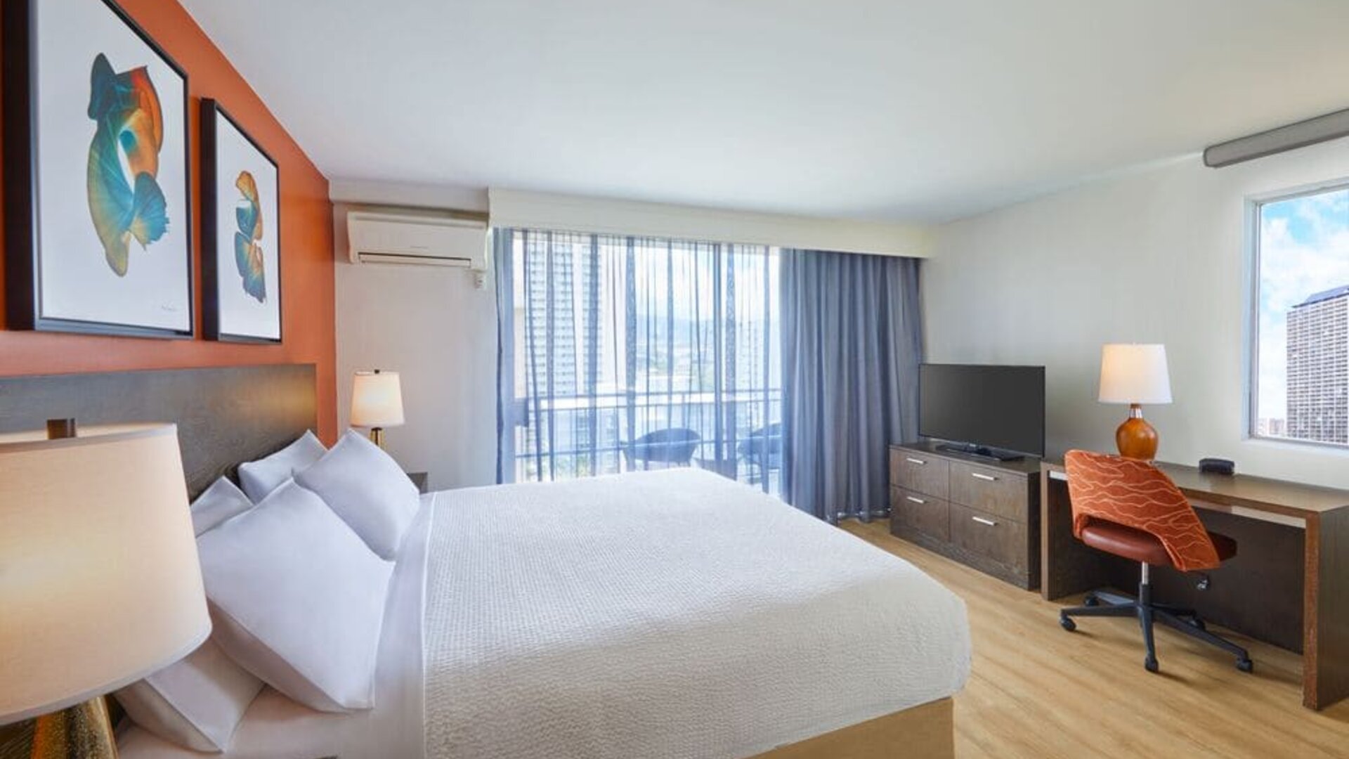 Modern king guest room with workspace and balcony at Courtyard Waikiki Beach.