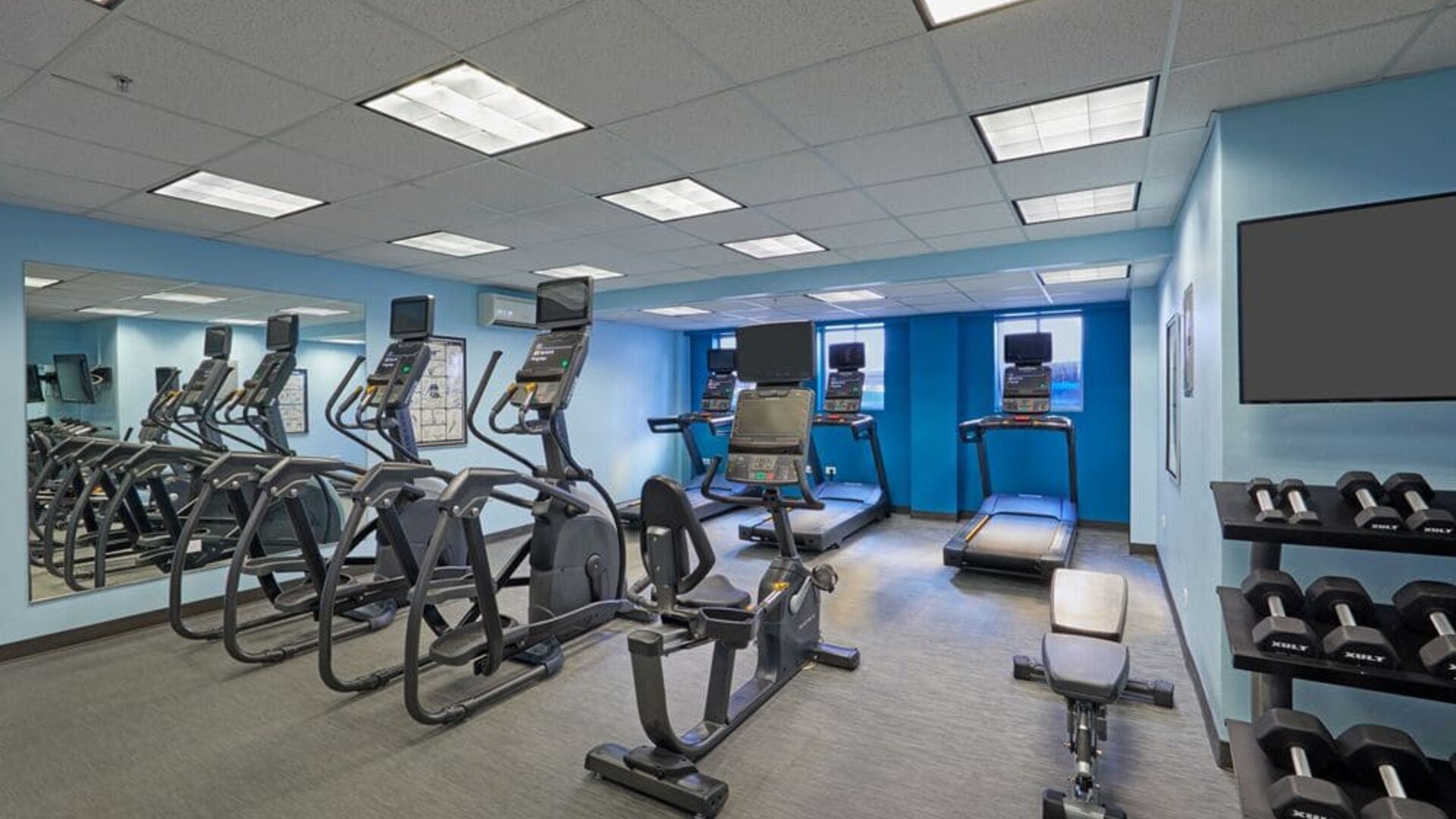 Fitness center with cardio and weight equipment at Courtyard Waikiki Beach.