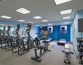 Fitness center with cardio and weight equipment at Courtyard Waikiki Beach.