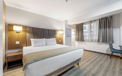 Bright king bedroom with comfortable bedding and workspace at Hotel Montreal Metropolitan, An Ascend Collection Hotel.