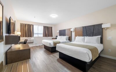 Double queen guest room with stylish finishes and workspace at Hotel Montreal Metropolitan, An Ascend Collection Hotel.