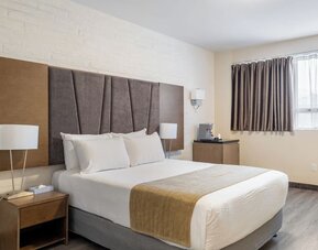 Contemporary king guest room with soft lighting and spacious layout at Hotel Montreal Metropolitan, An Ascend Collection Hotel.
