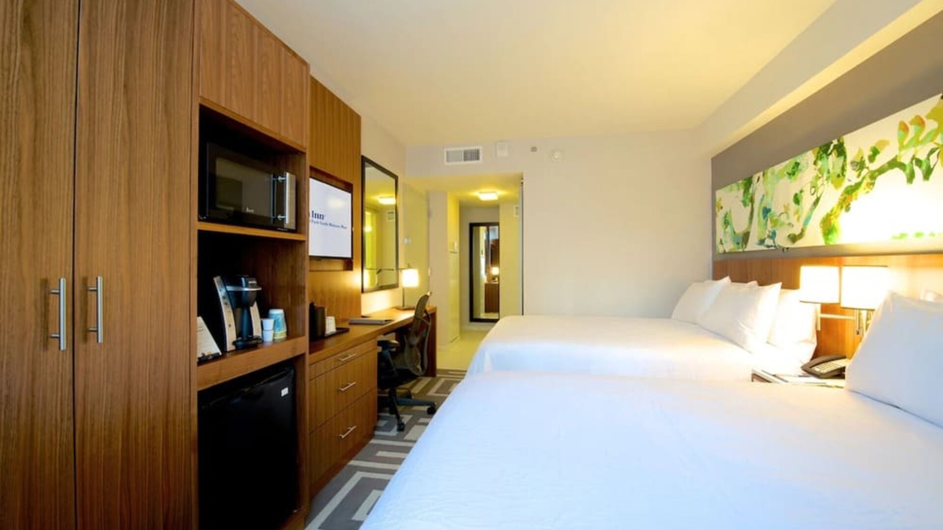 Spacious guest room with two double beds, workspace, and in-room amenities at Hilton Garden Inn New York Central Park South-Midtown West.