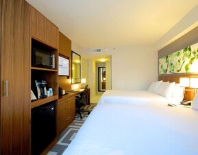 Spacious guest room with two double beds, workspace, and in-room amenities at Hilton Garden Inn New York Central Park South-Midtown West.