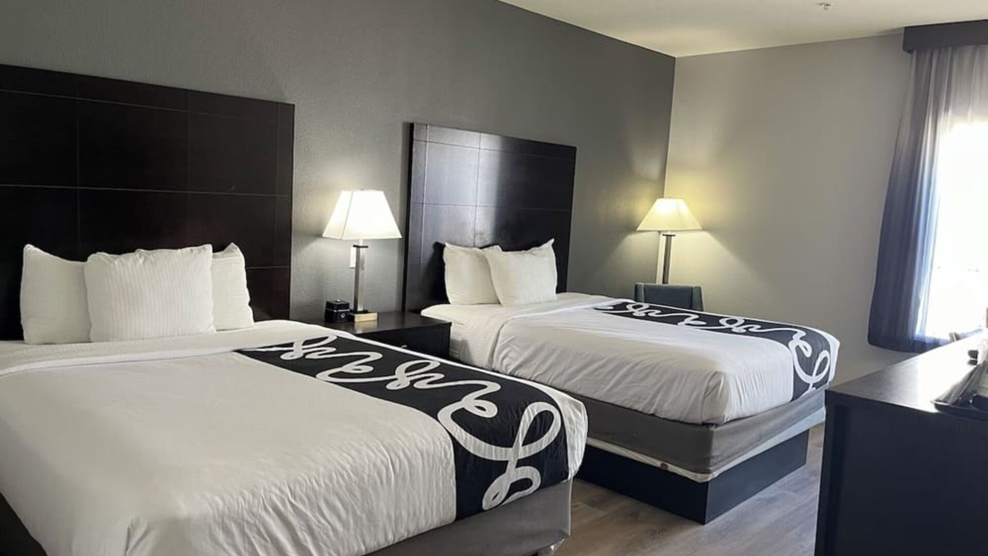 Guest room with two double beds and modern décor at La Quinta Inn & Suites By Wyndham Houston Energy Corridor.