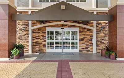 Front entrance with covered drop-off area at La Quinta Inn & Suites By Wyndham Houston Energy Corridor.