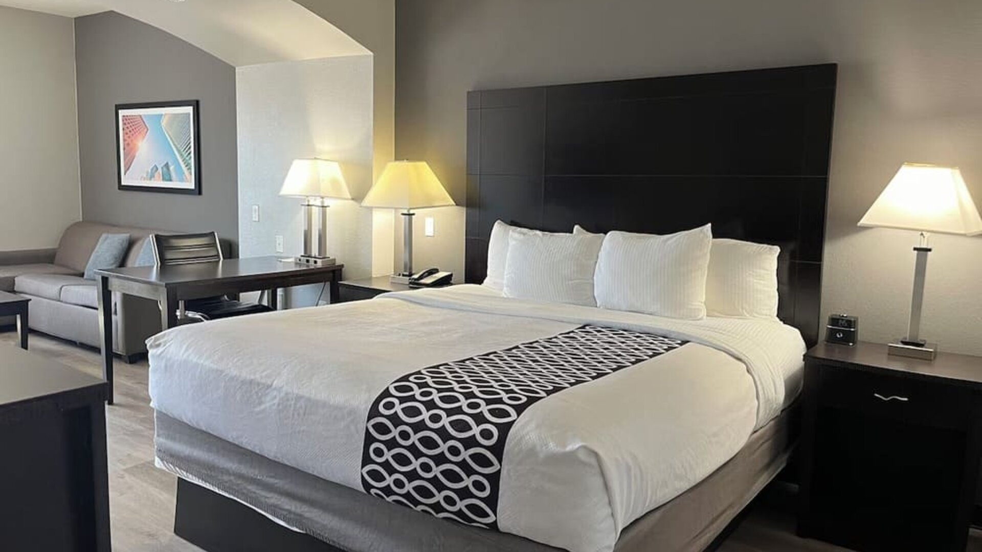 Guest room with seating area and workspace at La Quinta Inn & Suites By Wyndham Houston Energy Corridor.