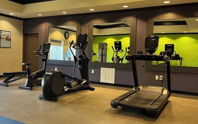 Hotel gym with treadmills, elliptical machines, and fitness equipment at La Quinta Inn & Suites By Wyndham Houston Energy Corridor.