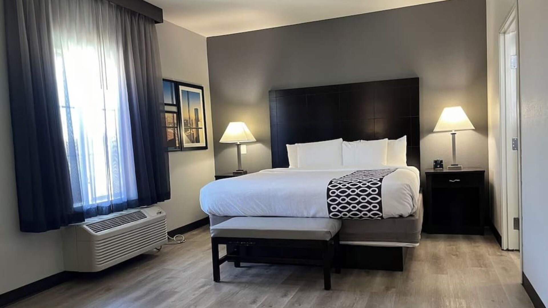 Comfortable king bedroom with natural lighting at La Quinta Inn & Suites By Wyndham Houston Energy Corridor.