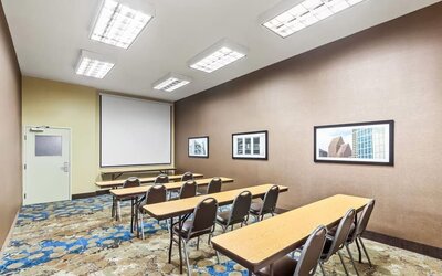 Meeting room with classroom-style seating and presentation screen at La Quinta Inn & Suites By Wyndham Houston Energy Corridor.