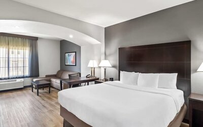 Spacious guest suite with king bed and lounge area at La Quinta Inn & Suites By Wyndham Houston Energy Corridor.
