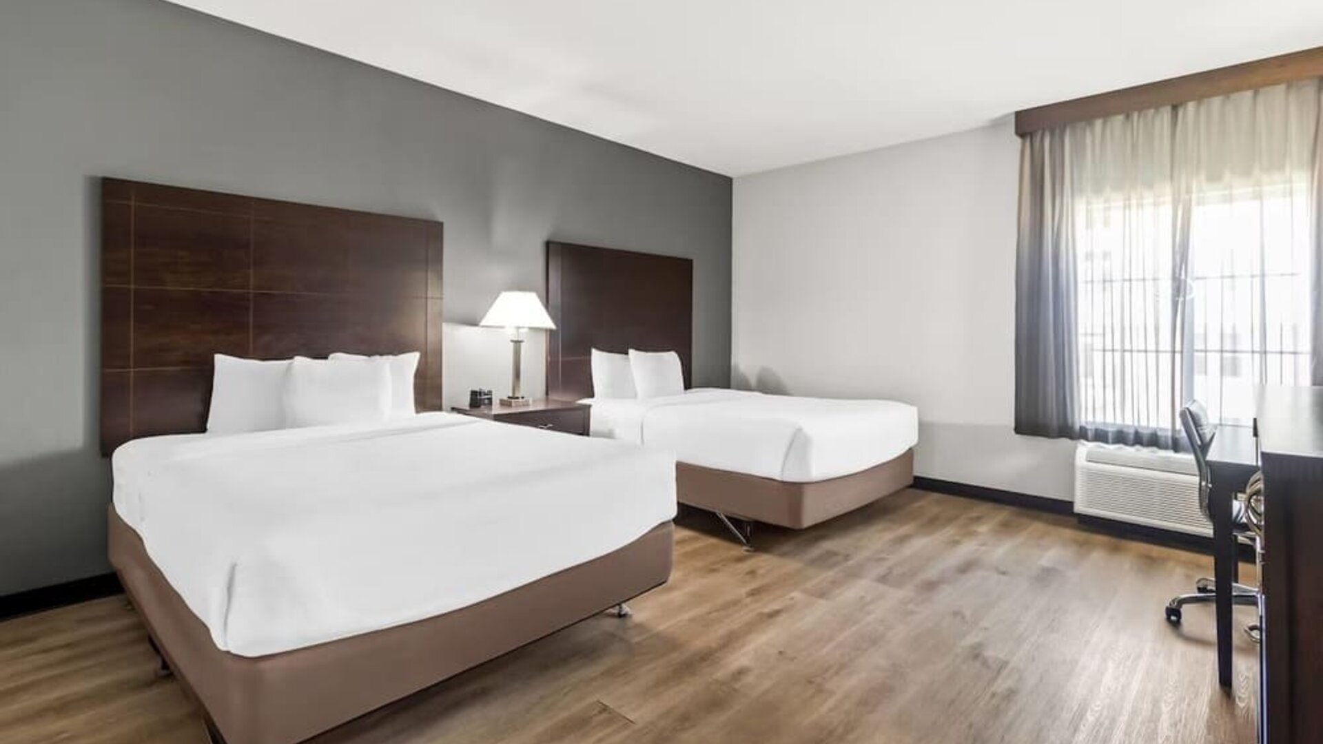 Guest room with two beds and workspace at La Quinta Inn & Suites By Wyndham Houston Energy Corridor.