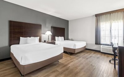 Guest room with two beds and workspace at La Quinta Inn & Suites By Wyndham Houston Energy Corridor.