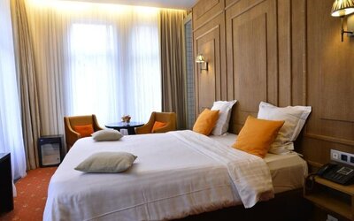 Spacious guest room with warm lighting, seating area, and contemporary furnishings at Hôtel Espérance.