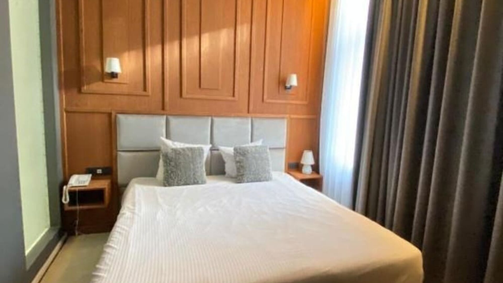Cozy day room with large curtains and modern décor at Hôtel Espérance.