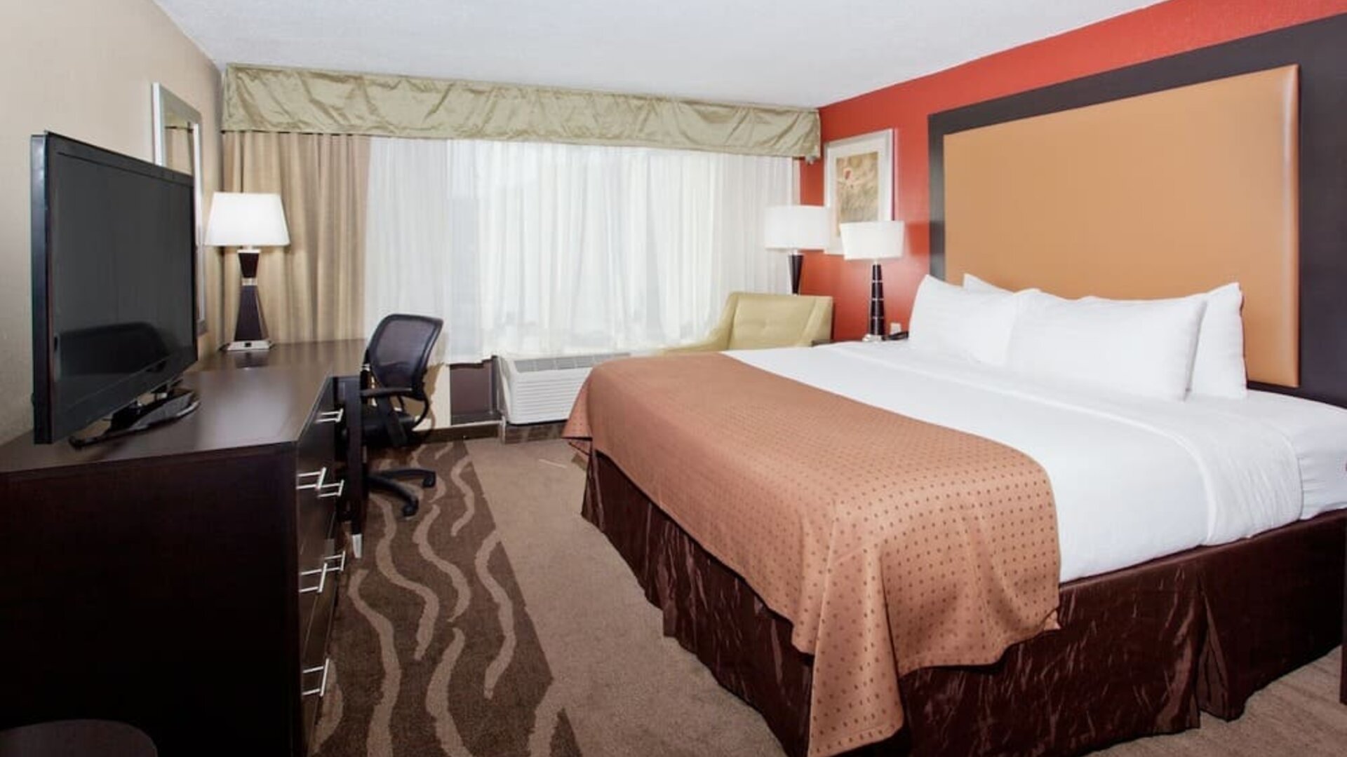 Spacious suite-style guest room with seating area and two beds at Holiday Inn Downtown Shreveport.