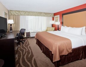 Spacious suite-style guest room with seating area and two beds at Holiday Inn Downtown Shreveport.