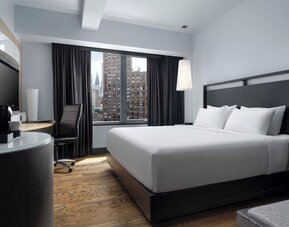 Contemporary guest room with king bed and large windows overlooking the city at Hyatt Union Square New York.