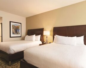 Room with two queen beds, bedside lighting, and framed wall art at Hilton Garden Inn Boston Logan Airport.