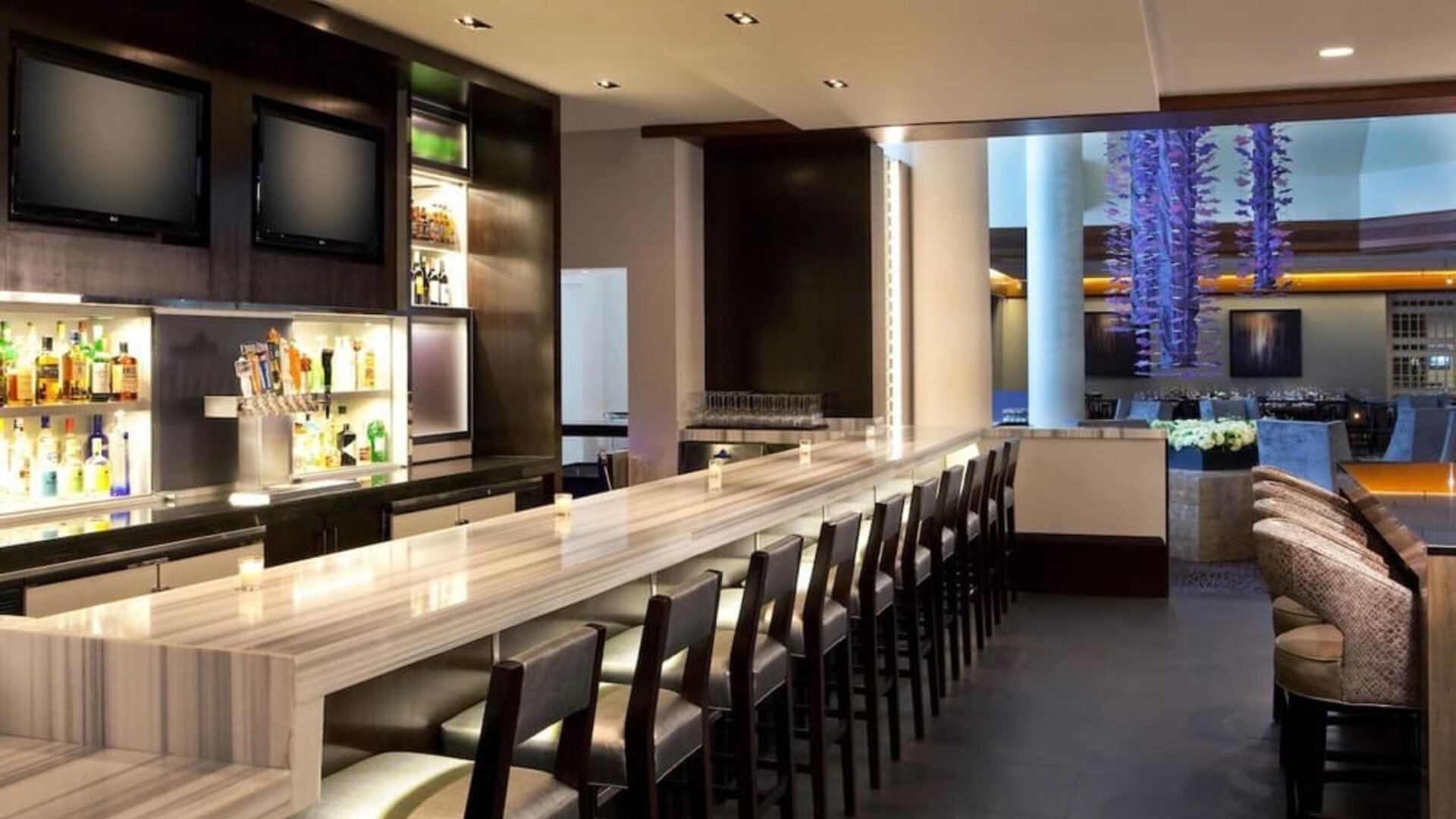 Contemporary hotel bar with marble countertops, high seating, and ambient lighting at Hyatt Regency Boston.