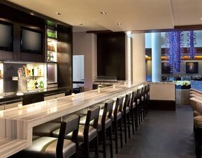 Contemporary hotel bar with marble countertops, high seating, and ambient lighting at Hyatt Regency Boston.