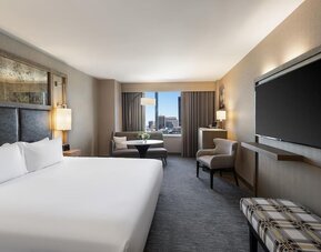 Contemporary king guest room with floor-to-ceiling windows, lounge seating, and city views at Hyatt Regency Boston.