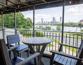 Outdoor terrace seating area with panoramic river and Boston skyline views at Hyatt Regency Boston/Cambridge.