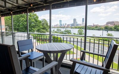 Outdoor terrace seating area with panoramic river and Boston skyline views at Hyatt Regency Boston/Cambridge.