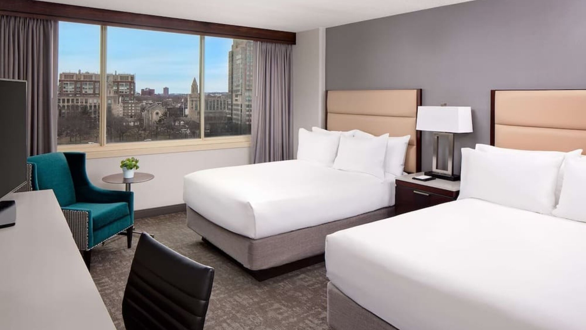 Spacious double queen guest room with large windows, city views, and modern furnishings at Hyatt Regency Boston/Cambridge.