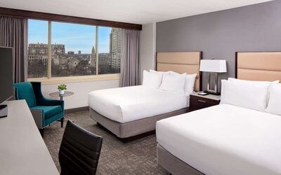 Spacious double queen guest room with large windows, city views, and modern furnishings at Hyatt Regency Boston/Cambridge.