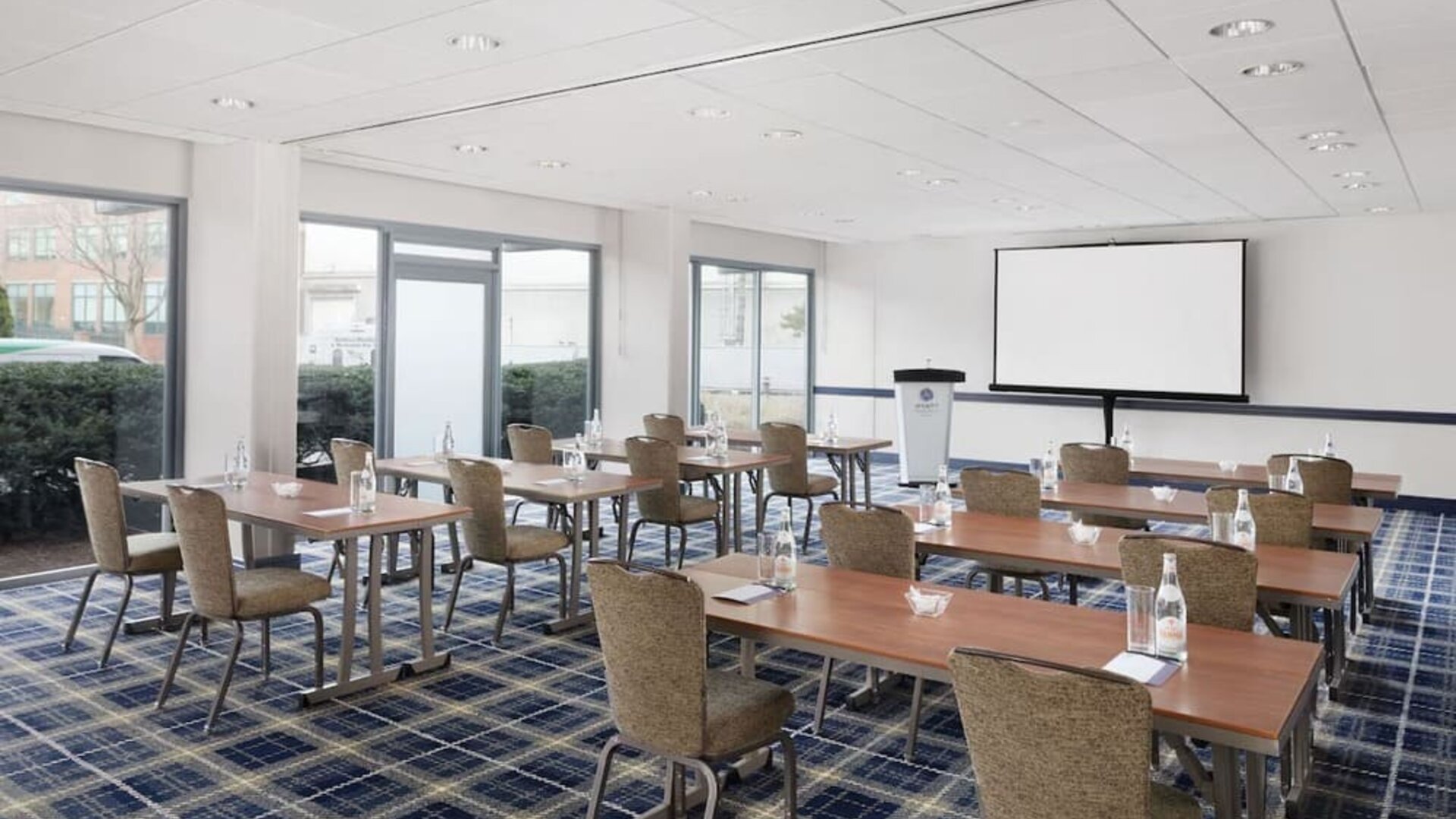 Bright meeting and conference room with classroom-style setup and presentation screen at Hyatt Regency Boston/Cambridge.