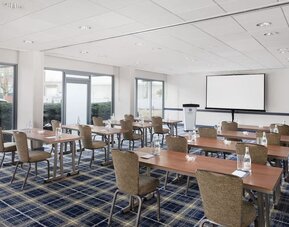 Bright meeting and conference room with classroom-style setup and presentation screen at Hyatt Regency Boston/Cambridge.