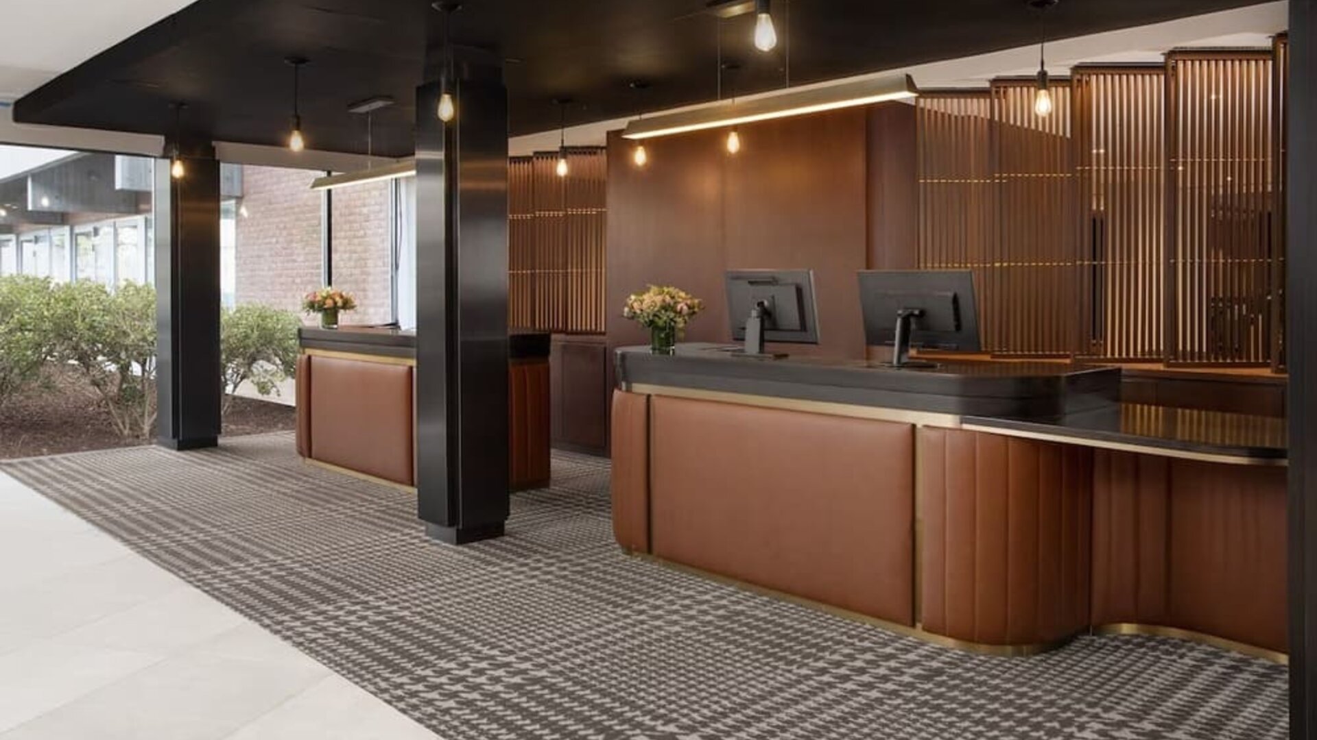 Modern hotel reception desk area with warm wood finishes and contemporary lighting at Hyatt Regency Boston/Cambridge.