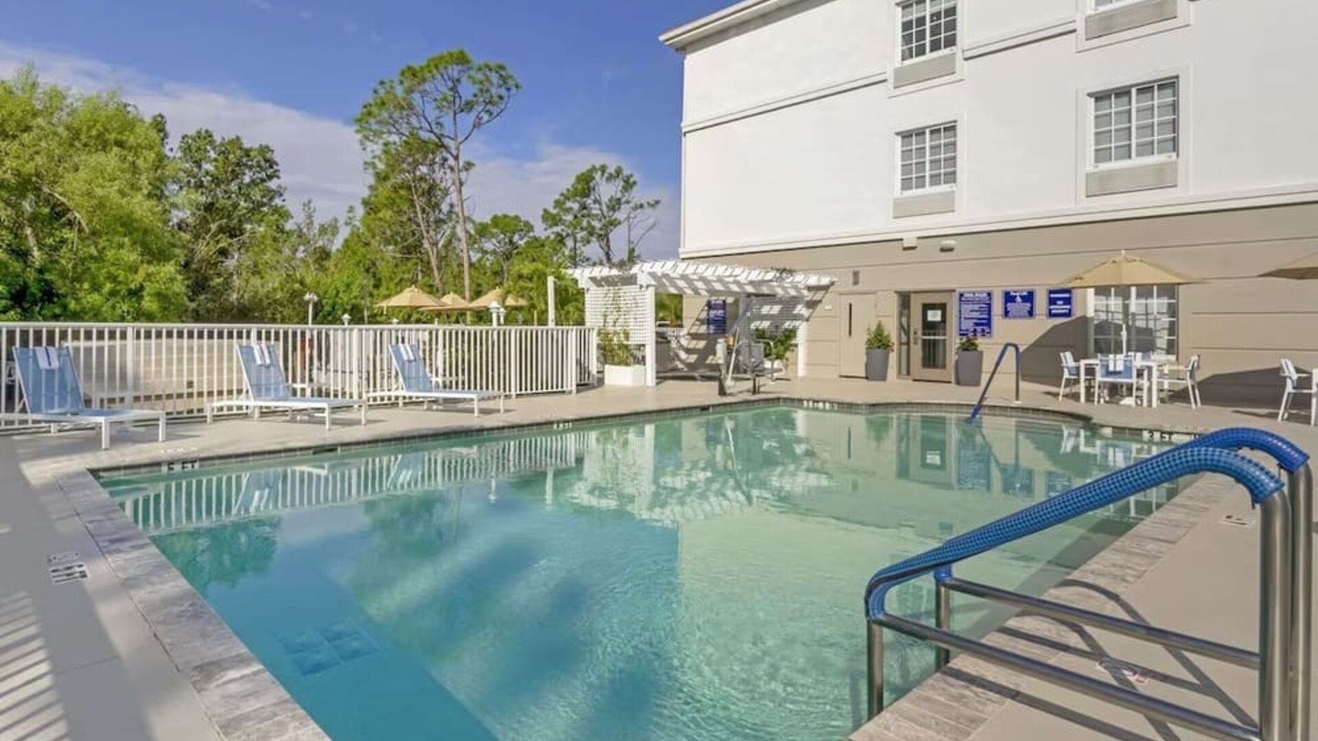 Outdoor swimming pool area with lounge chairs and shaded seating at Comfort Inn & Suites Port Charlotte-Punta Gorda.
