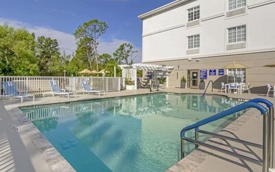 Outdoor swimming pool area with lounge chairs and shaded seating at Comfort Inn & Suites Port Charlotte-Punta Gorda.