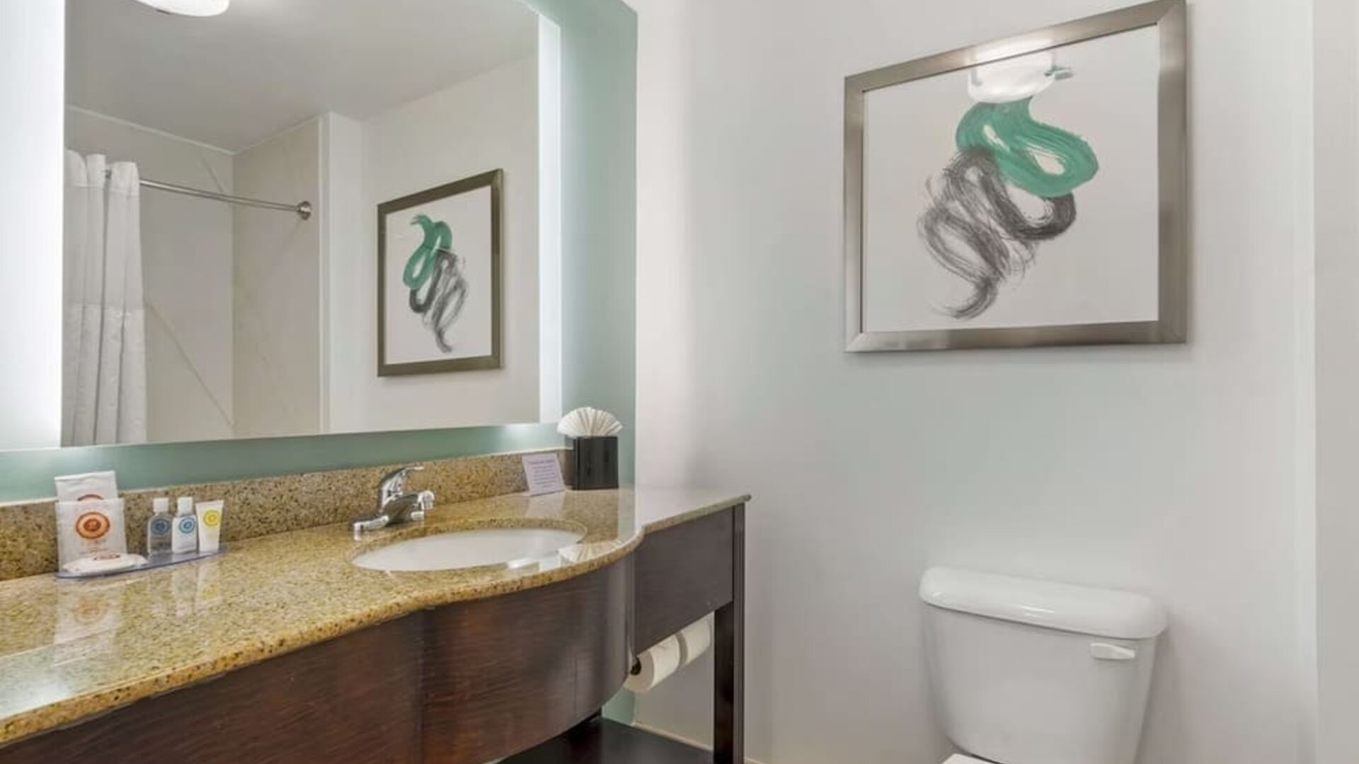 Modern guest bathroom with granite vanity countertop, illuminated mirror, and contemporary décor at Comfort Inn & Suites Port Charlotte-Punta Gorda.