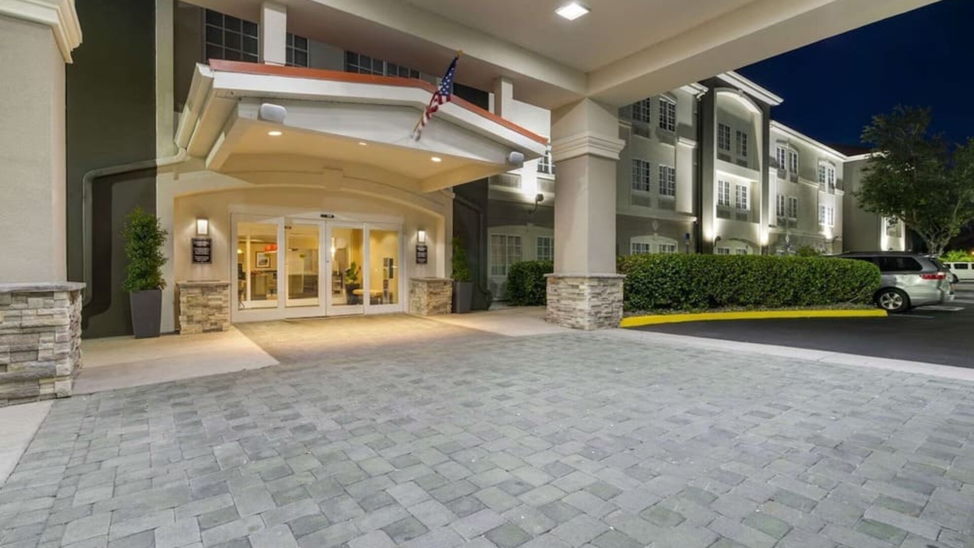 Covered hotel entrance illuminated at night with landscaped surroundings at Comfort Inn & Suites Port Charlotte-Punta Gorda.
