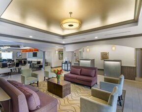 Spacious hotel lobby with comfortable seating, reception area, and modern lighting at Comfort Inn & Suites Port Charlotte-Punta Gorda.