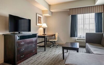 Studio-style suite with sofa seating, workspace, and flat-screen television at Comfort Inn & Suites Port Charlotte-Punta Gorda.