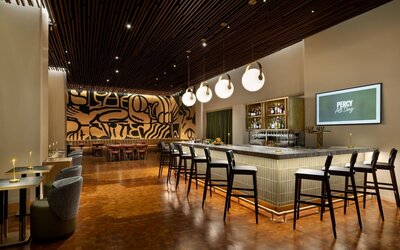 Sophisticated cocktail bar area with elegant seating, warm lighting, and artistic interior design at Row NYC.