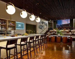 Stylish hotel bar and lounge area with contemporary lighting, upscale seating, and modern décor at Row NYC.