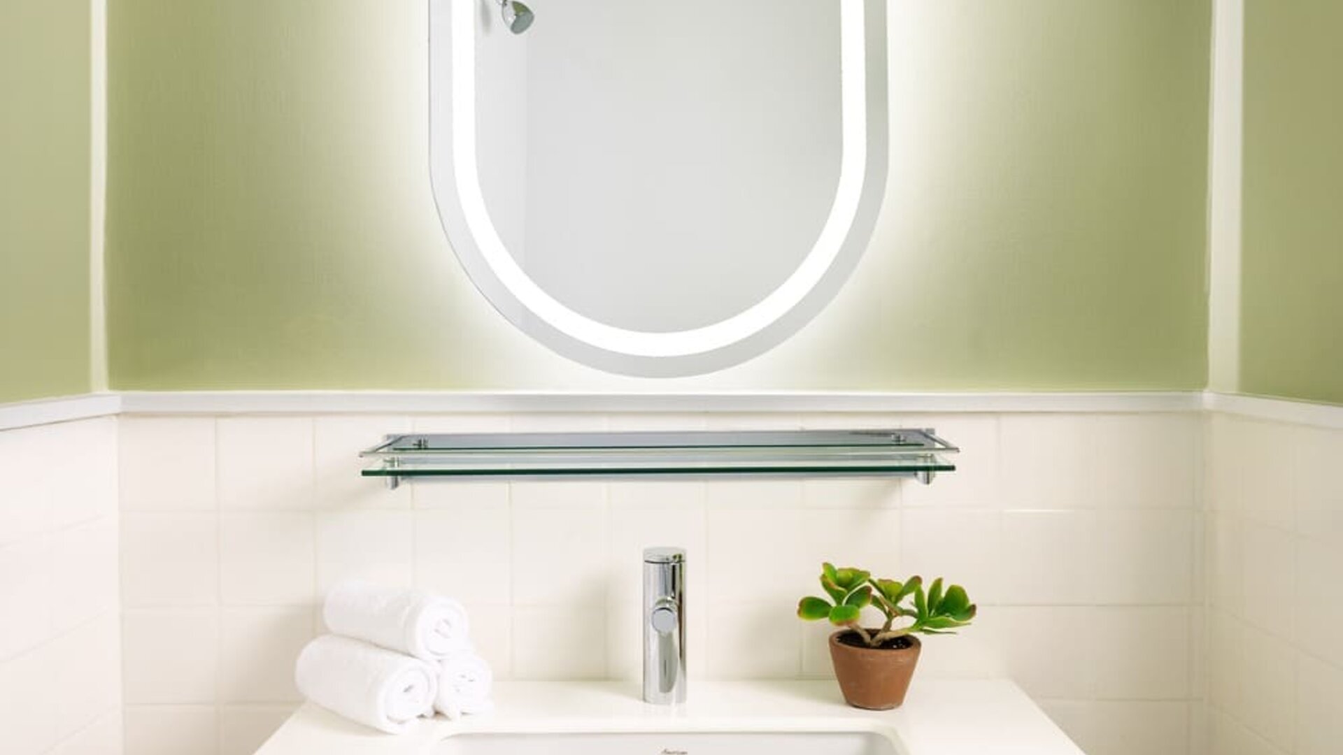 Modern bathroom vanity with illuminated mirror, contemporary sink, and minimalist styling at Row NYC.