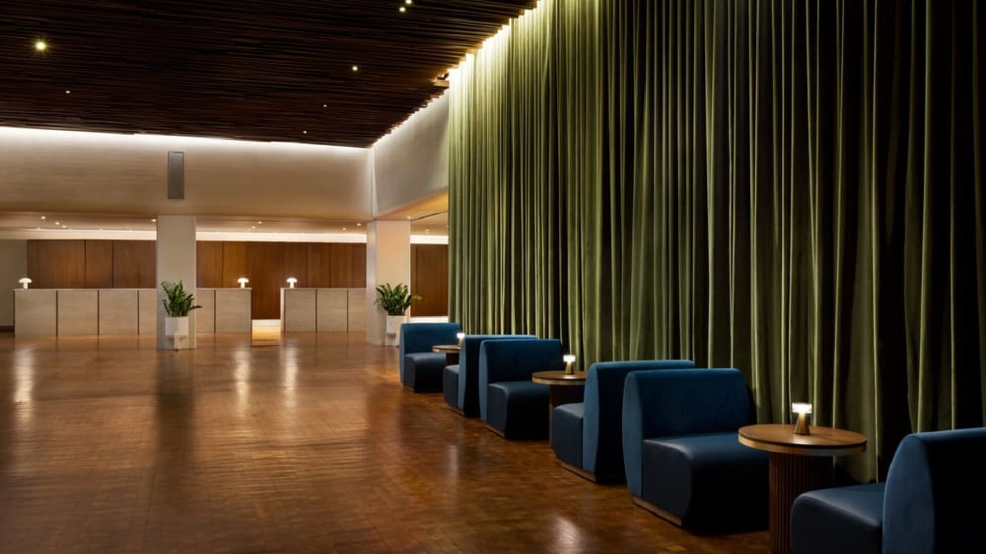 Elegant reception and lounge area with plush seating, dramatic curtains, and sophisticated lighting at Row NYC.