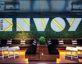 Trendy rooftop lounge area with illuminated seating, modern décor, and vibrant nightlife atmosphere at The Envoy Hotel, Autograph Collection.