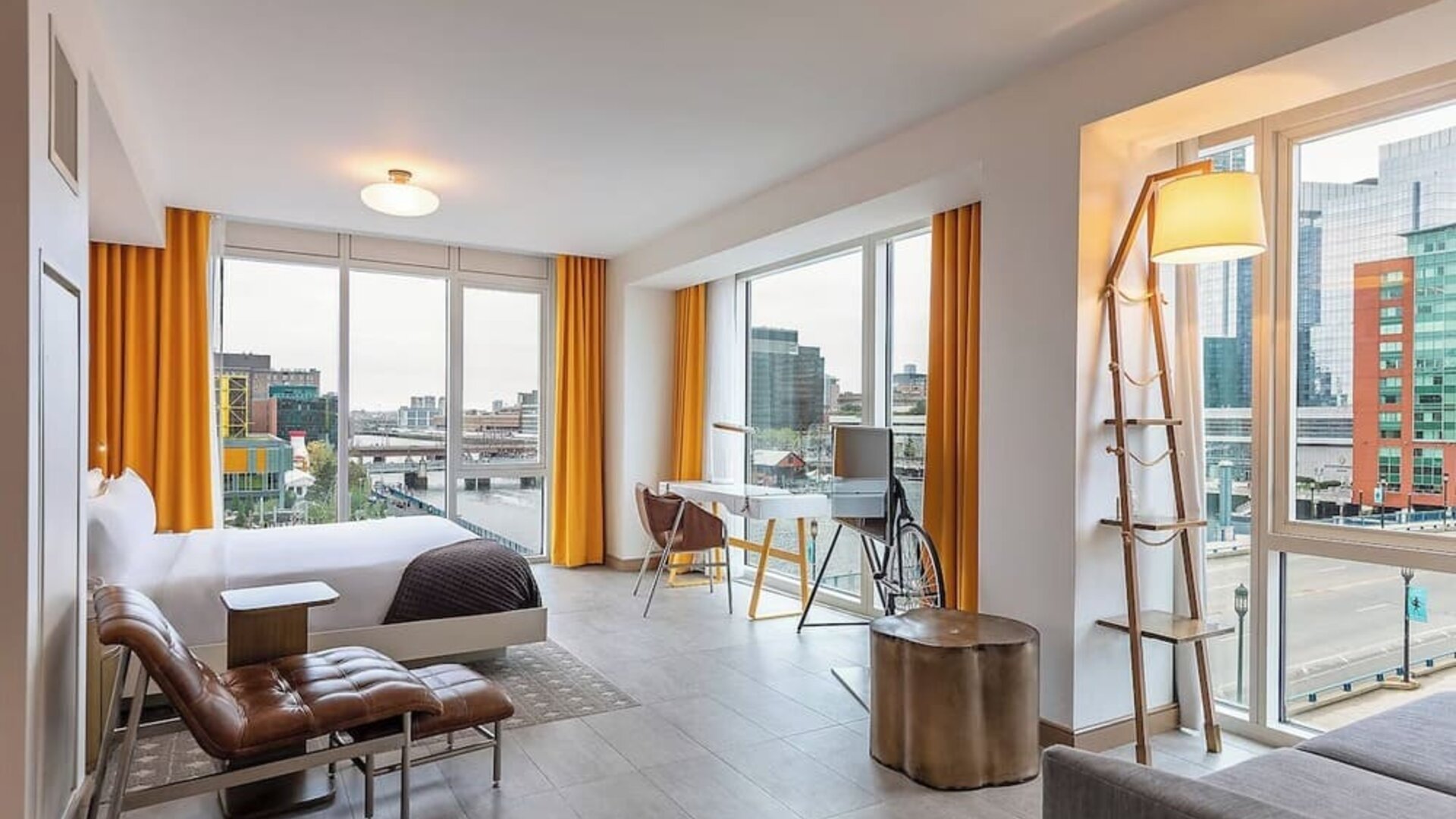 Spacious modern suite with open-plan design, city views, contemporary décor, and comfortable lounge seating at The Envoy Hotel, Autograph Collection.