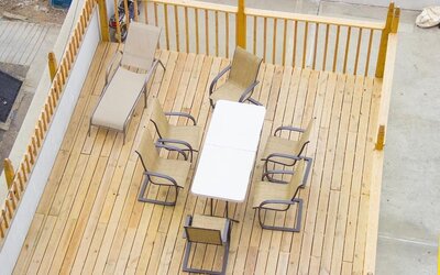 Outdoor seating deck with lounge chairs and dining table available for guests at Phoenix Hotel Brooklyn Sunset Park.