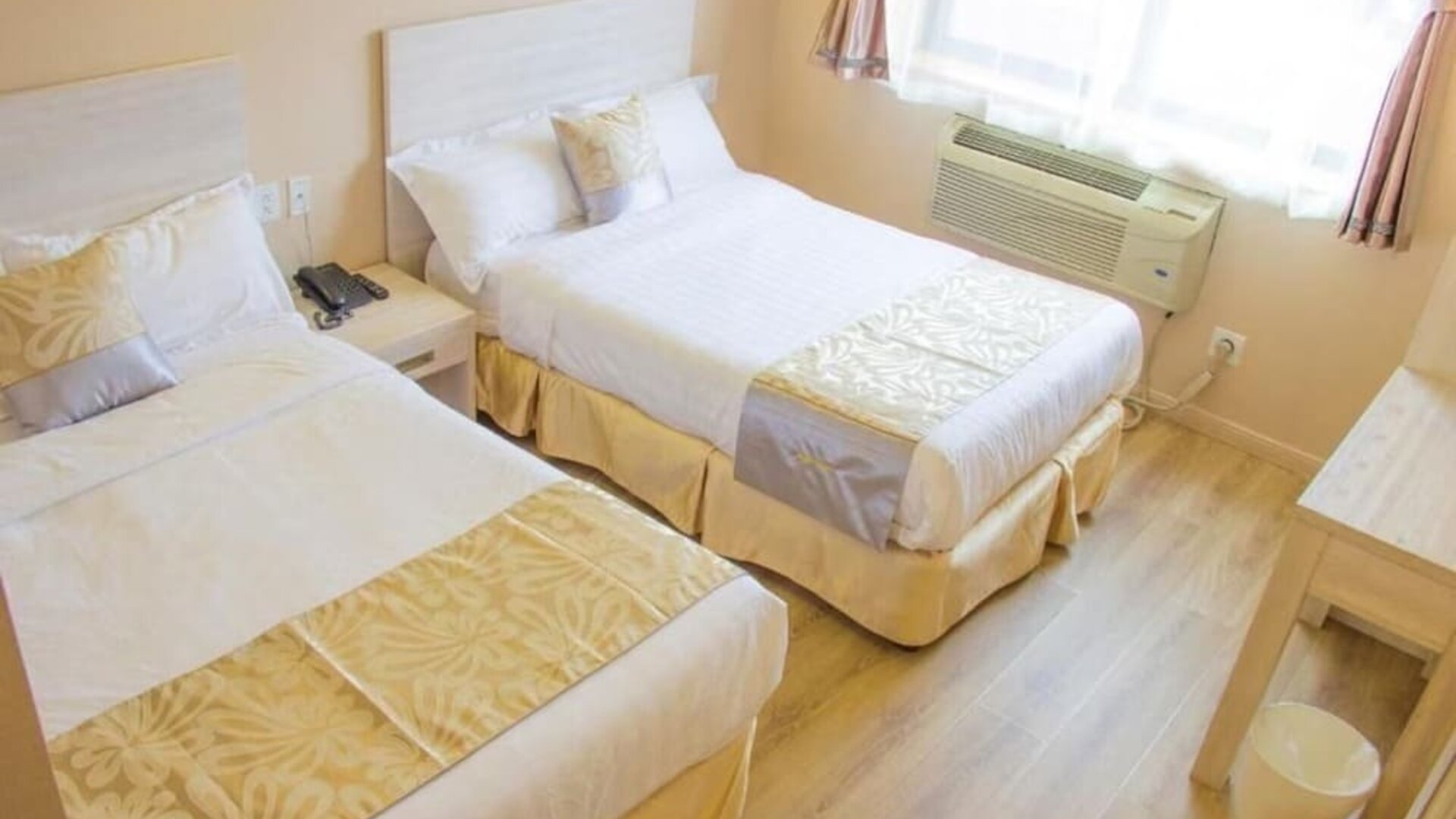 Comfortable twin-bed guest room with bright interiors and modern accommodations at Phoenix Hotel Brooklyn Sunset Park.