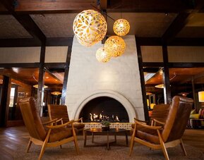 Cozy lobby fireplace lounge with modern lighting, leather seating, and warm communal gathering spaces at The Garland.