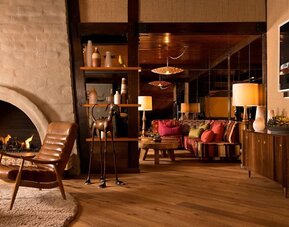 Elegant lobby seating area with a fireplace, wood finishes, and comfortable lounge spaces designed for relaxation at The Garland.