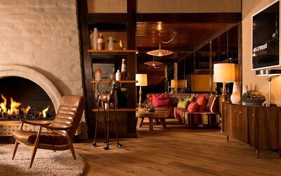 Elegant lobby seating area with a fireplace, wood finishes, and comfortable lounge spaces designed for relaxation at The Garland.